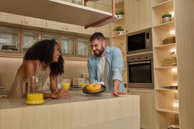 Casal tomando café numa cozinha em madeira clara