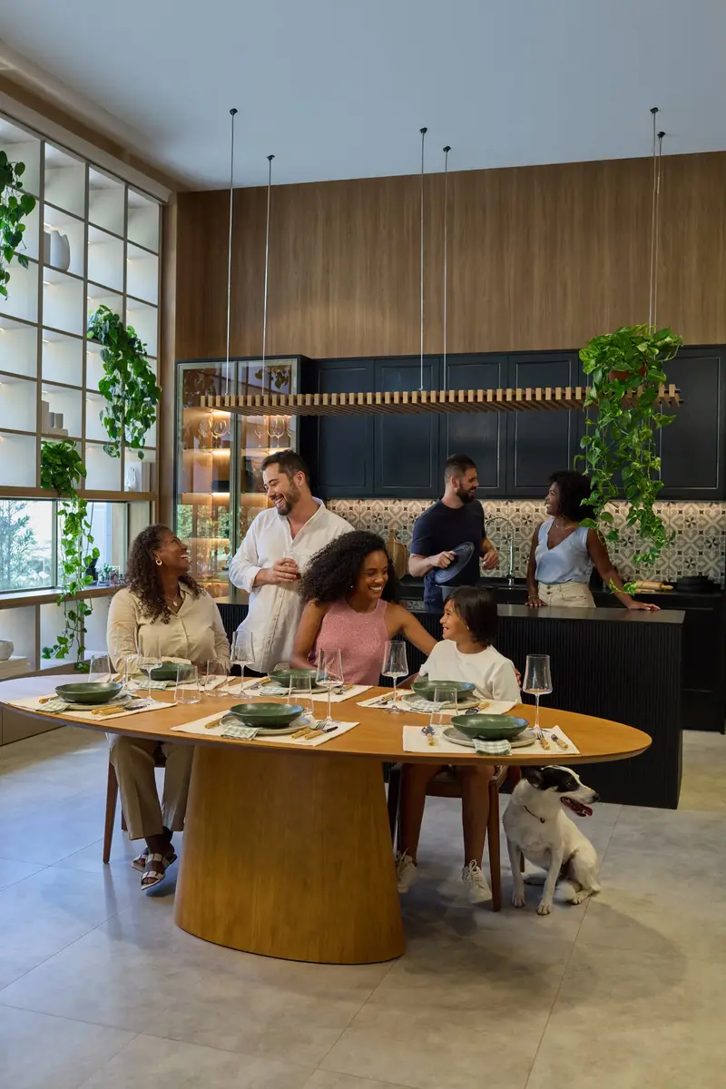 Família reunida à mesa numa cozinha planejada